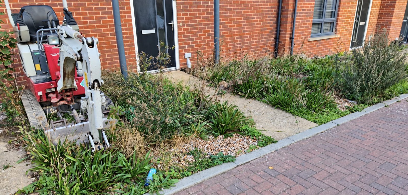 Overgrown front garden beds and an old concrete path before a new block paving driveway, Kent